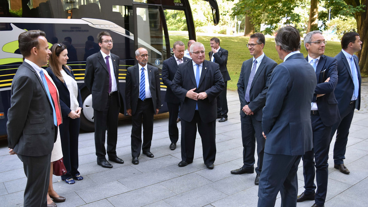 Landtagspräsident Schlie begrüßt seine Gäste vor dem Eingangsportal des Landeshauses.